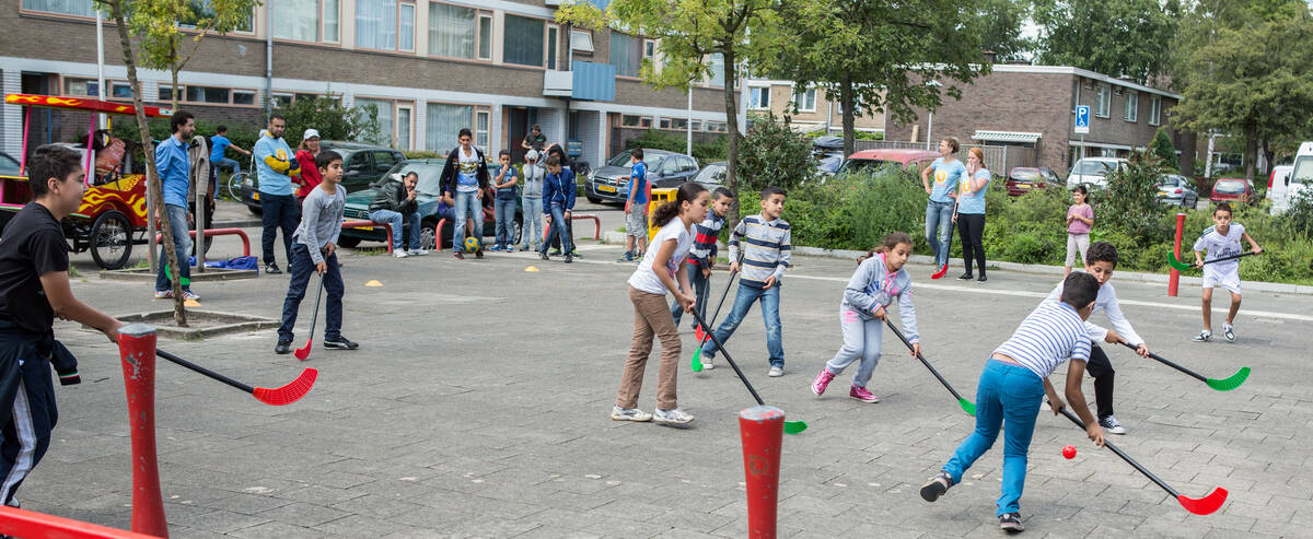 Kinderenspelen hockey op een pleintje