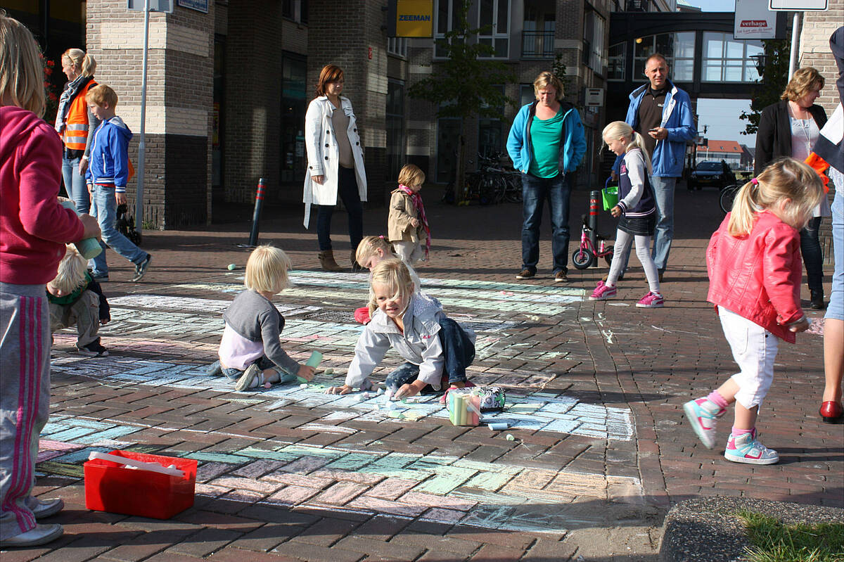 kinderen maken tekeningen met krijt op de stoep, in winkelcentrum Vleuterweide