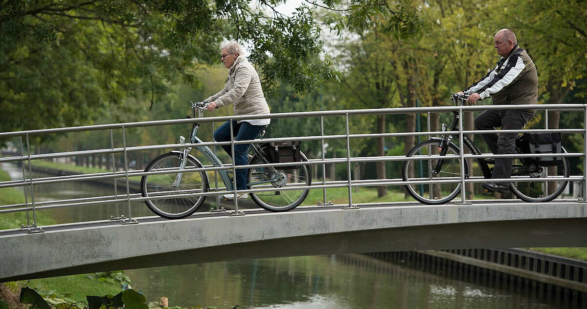 twee fietsers op een fietsbrug over het water