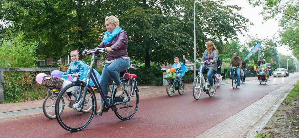 moeder fietst met kinderen over een fietsstraat