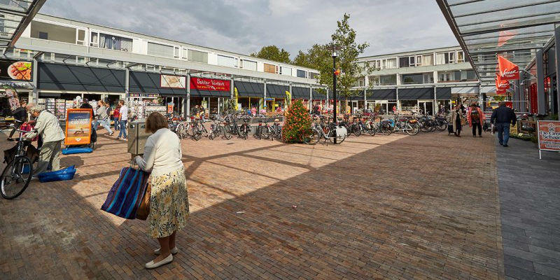 winkelcentrum Mereveldplein, een vrouw loopt met boodschappentas over het plein